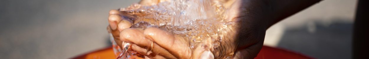african-woman-pouring-water-recipient-outdoors